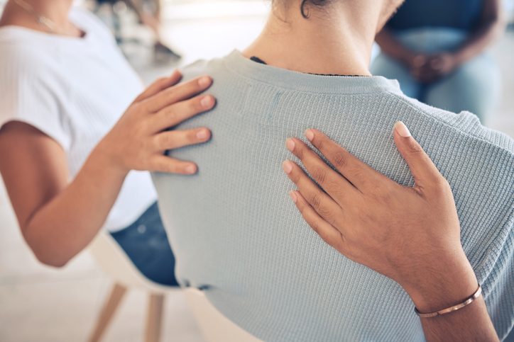 Hands, mental health and support in group therapy for woman suffering depression, stress and trauma closeup. Hand, people and aa meeting by community in trust, help and empathy for girl with anxiety